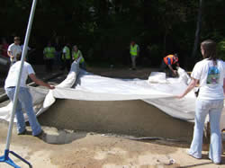 Placing plastic sheeting over pervious concrete